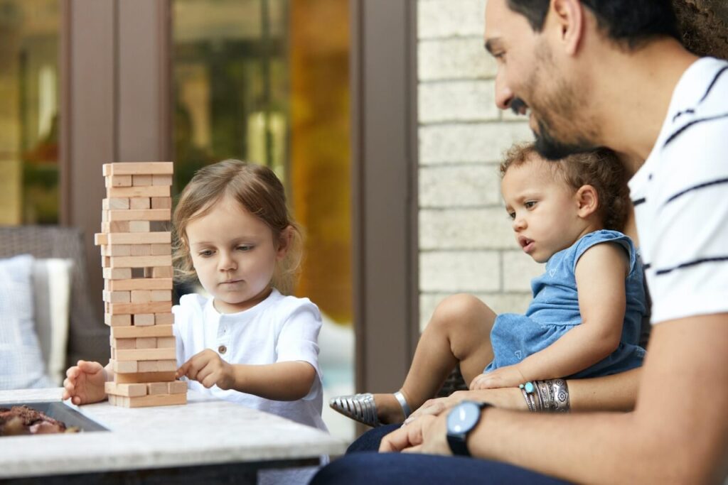 Young girl playing Jenga with her Father 