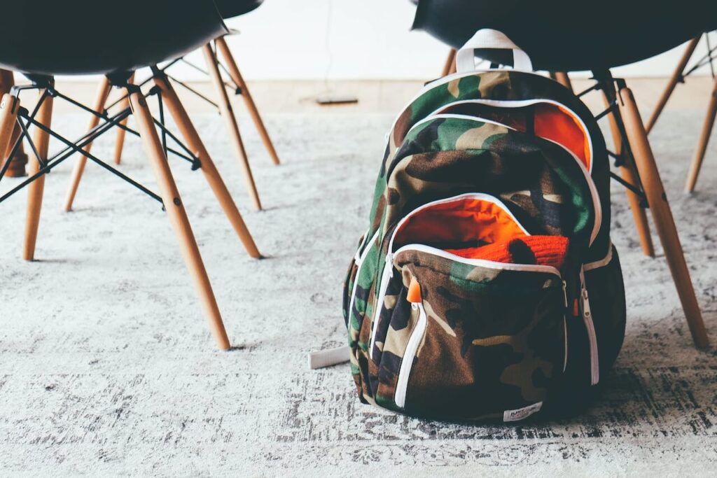 A child's rucksack on the floor by rows of chairs