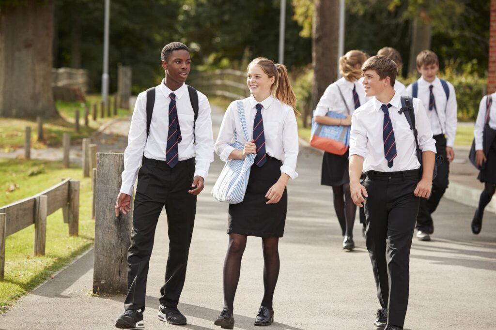 A group of teenagers in school uniform walking along and chatting