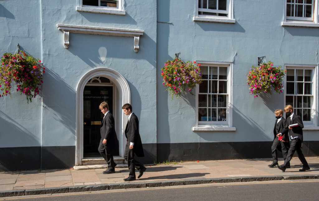 Eton college pupils walking down a street